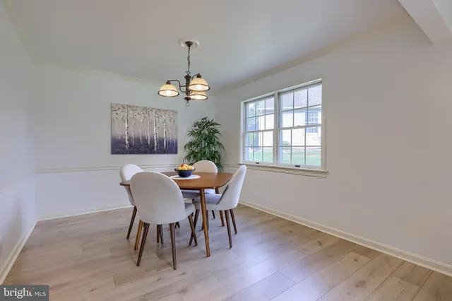 a dining room with furniture a chandelier and wooden floor