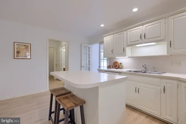 a kitchen with stainless steel appliances a sink a stove a refrigerator and cabinets