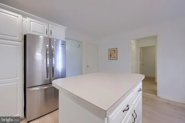 a kitchen with refrigerator cabinets and wooden floor