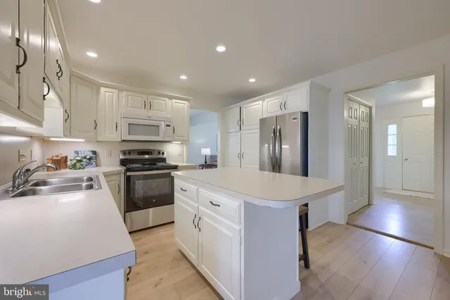 a kitchen with stainless steel appliances a refrigerator sink and stove