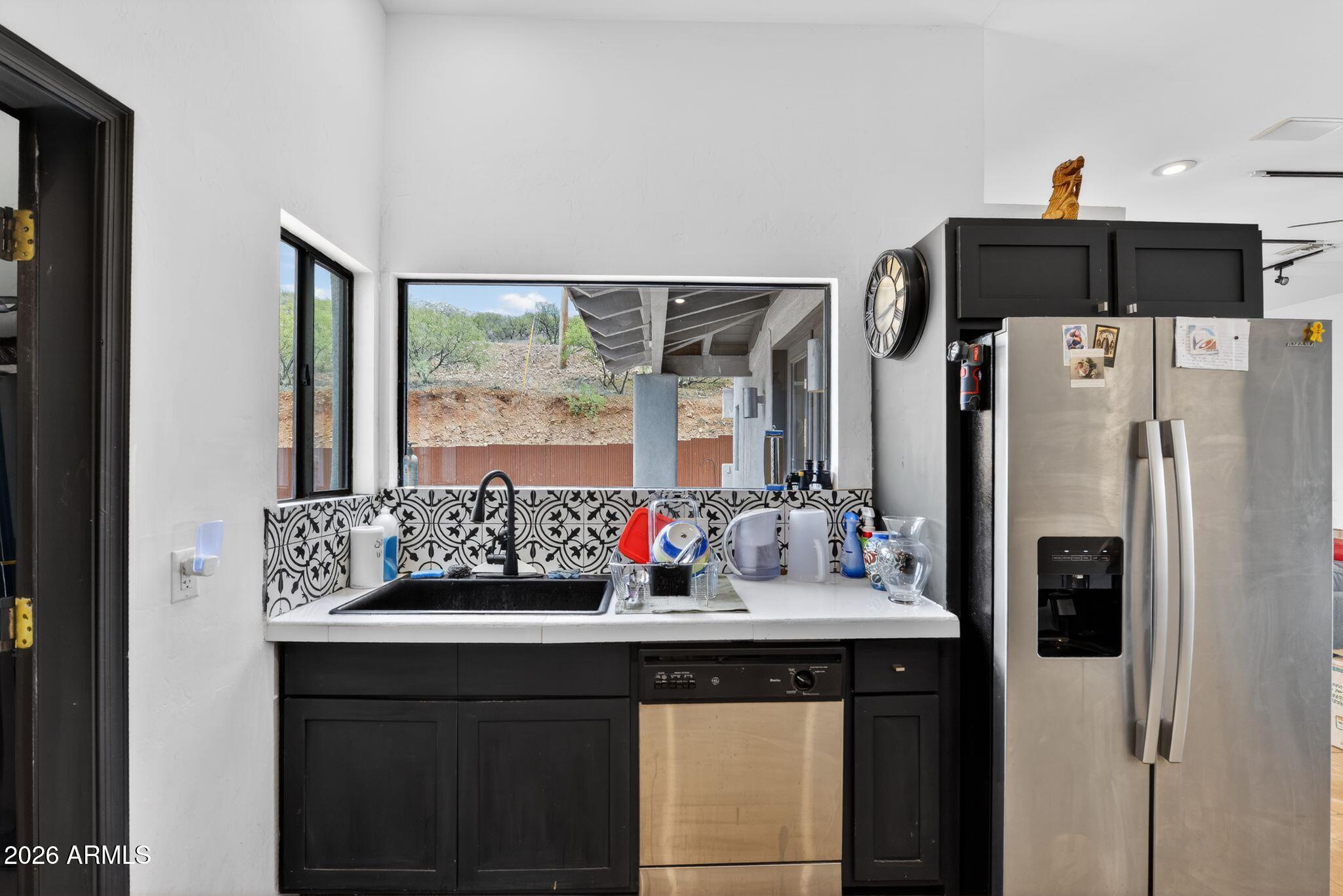 277 Círculo Silva Rio Rico, AZ 85648 - Photo 15 of 34 a kitchen with stainless steel appliances a sink and a refrigerator
