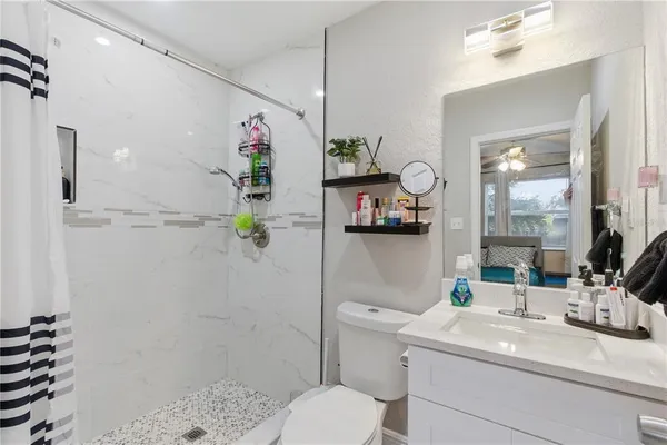 a bathroom with a sink a toilet and shower
