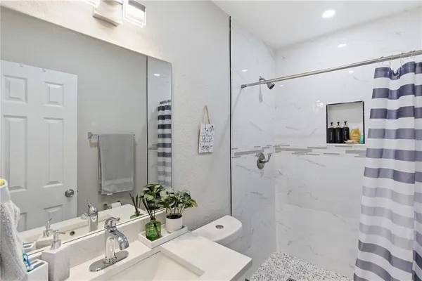 a bathroom with a sink mirror and shower