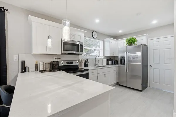 a kitchen with white cabinets and stainless steel appliances