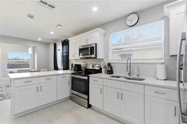 a kitchen with a sink stove and microwave