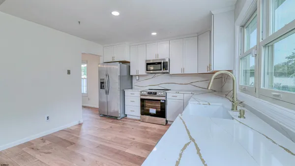 a kitchen with stainless steel appliances granite countertop a refrigerator and a stove top oven