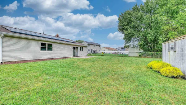 a view of a house with backyard and garden