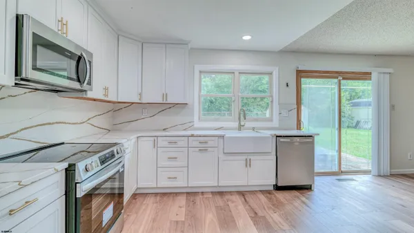 a kitchen with cabinets appliances and a large window