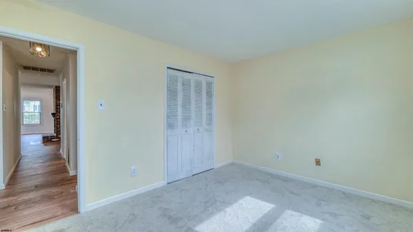 a view of a big room with wooden floor and a window