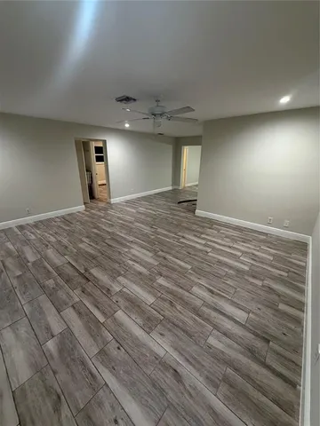 a view of empty room with wooden floor