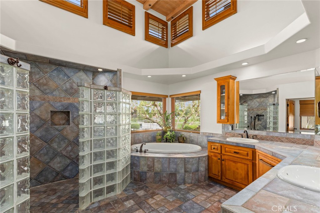 43991 John Warner Road Temecula, CA 92592 - Photo 20 of 39 a spacious bathroom with a granite countertop sink a mirror a bathtub and a shower