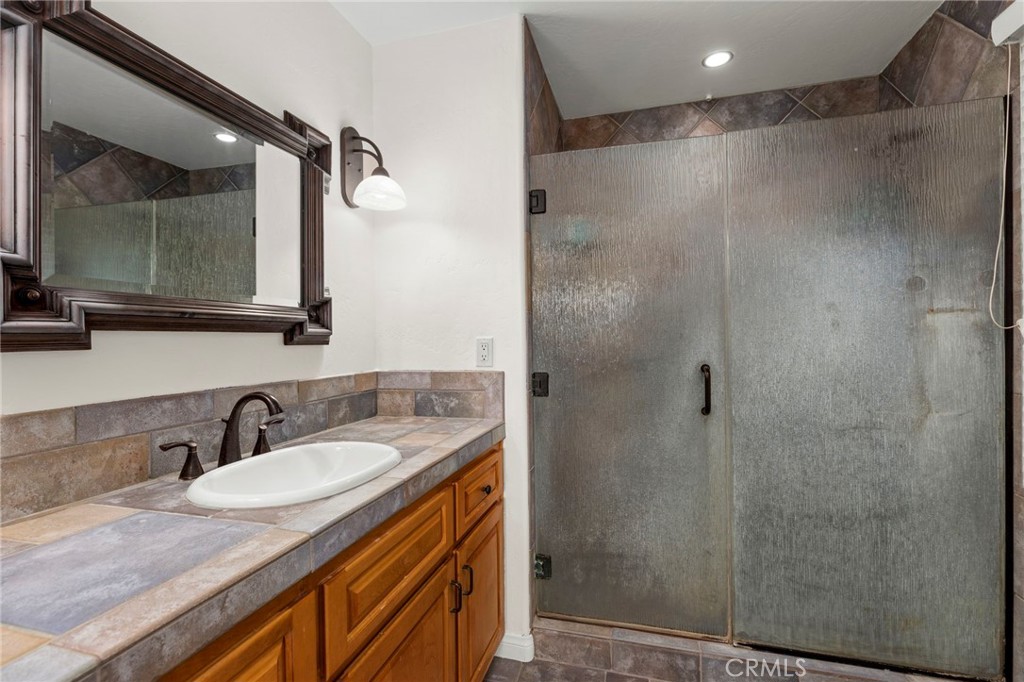 43991 John Warner Road Temecula, CA 92592 - Photo 27 of 39 a bathroom with a granite countertop sink shower and mirror