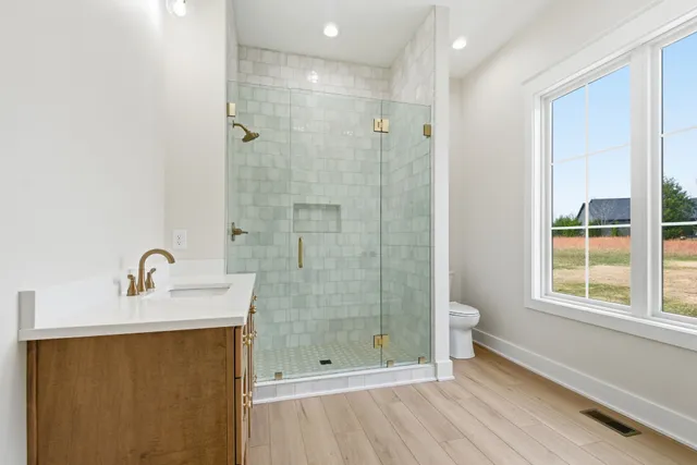 a bathroom with a sink a toilet and shower