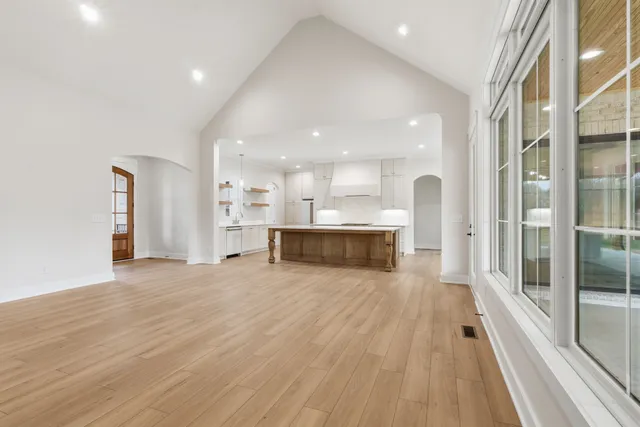a view of a big room with wooden floor and windows
