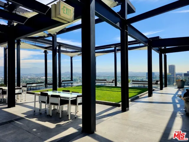 a view of a kitchen with stainless steel appliances dining table chairs and a large window