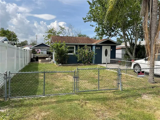 a view of a house with a big yard and a large tree