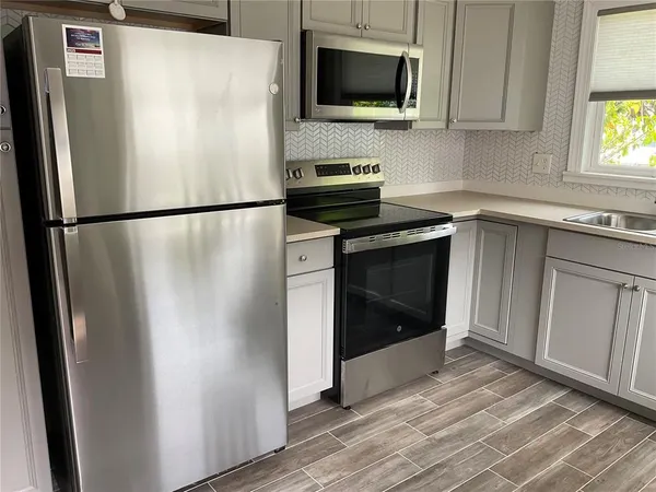 a white refrigerator freezer and a stove sitting inside of a kitchen
