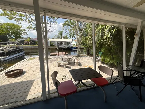 a living room with patio furniture and a floor to ceiling window