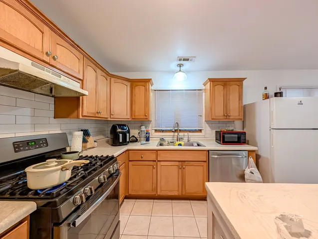 a kitchen with stainless steel appliances granite countertop a stove and a white cabinets