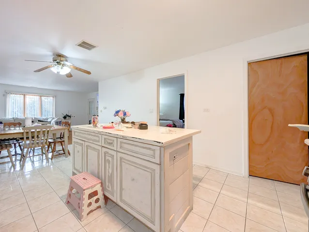a very nice looking open kitchen with stainless steel appliances granite countertop a refrigerator and a stove top oven