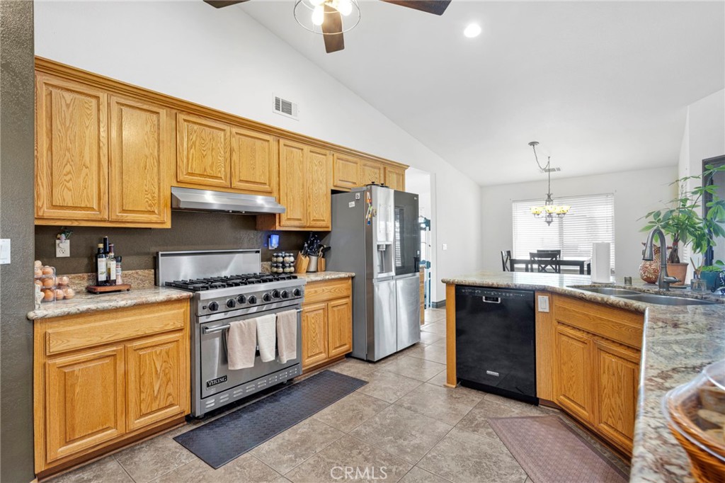 13724 Yuma Road Apple Valley, CA 92307 - Photo 18 of 75 a kitchen with stainless steel appliances granite countertop a stove a sink dishwasher and a refrigerator
