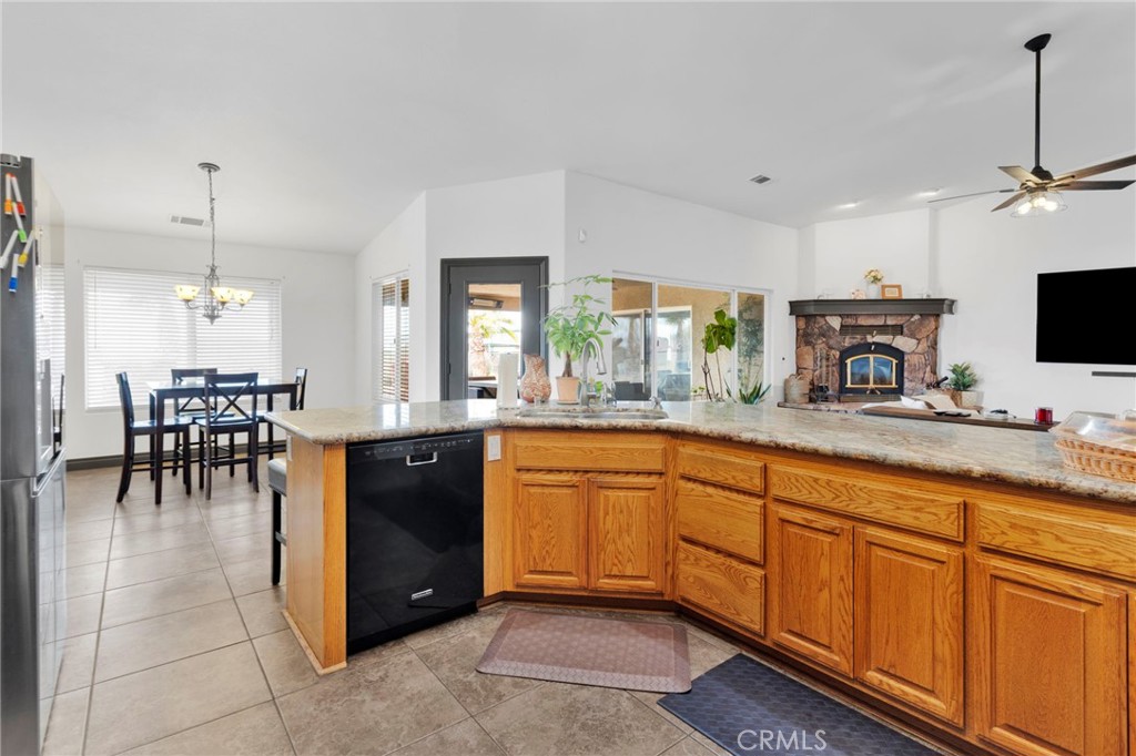 13724 Yuma Road Apple Valley, CA 92307 - Photo 20 of 75 a large kitchen with kitchen island granite countertop a large counter space a sink appliances and a view of living room