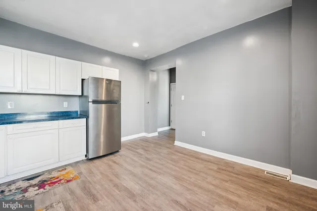 a view of kitchen with refrigerator cabinets and wooden floor