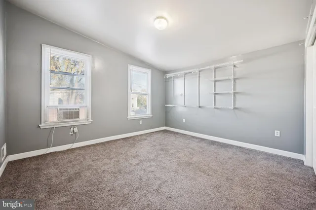 an empty room with windows and closet