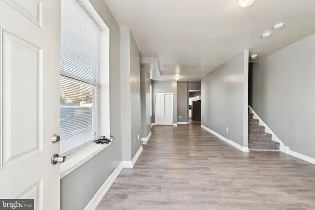 a view of a hallway with wooden floor and staircase