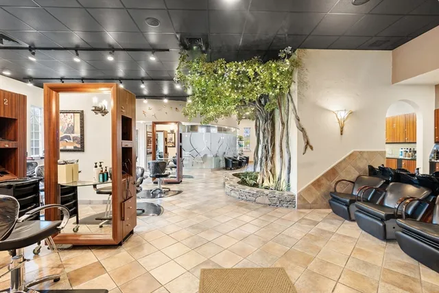a room with lots of white furniture and a chandelier