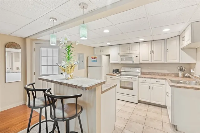 a kitchen with stainless steel appliances granite countertop a table chairs sink and cabinets
