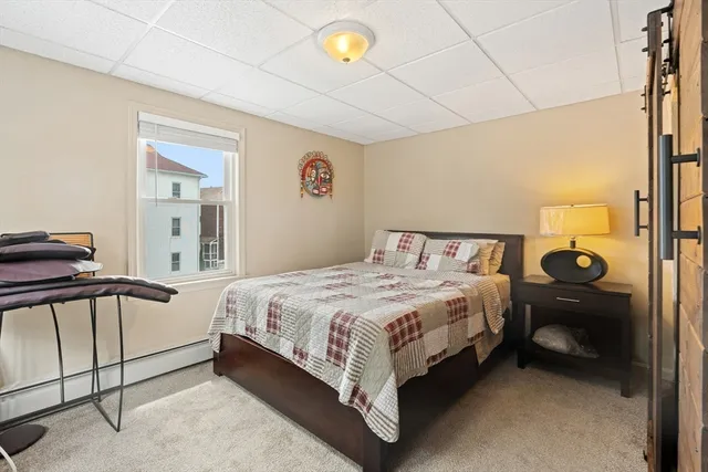 a bedroom with a bed and a lamp with the dresser