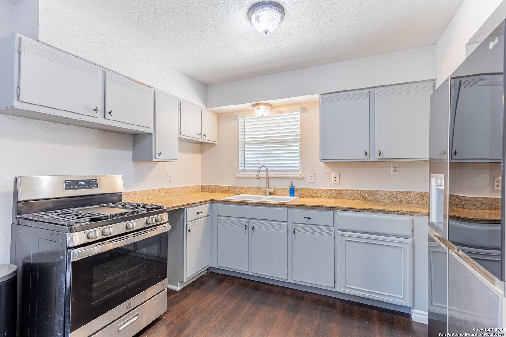 7802 Rimfire Drive San Antonio, TX 78227 - Photo 11 of 39 a kitchen with granite countertop white cabinets and stainless steel appliances