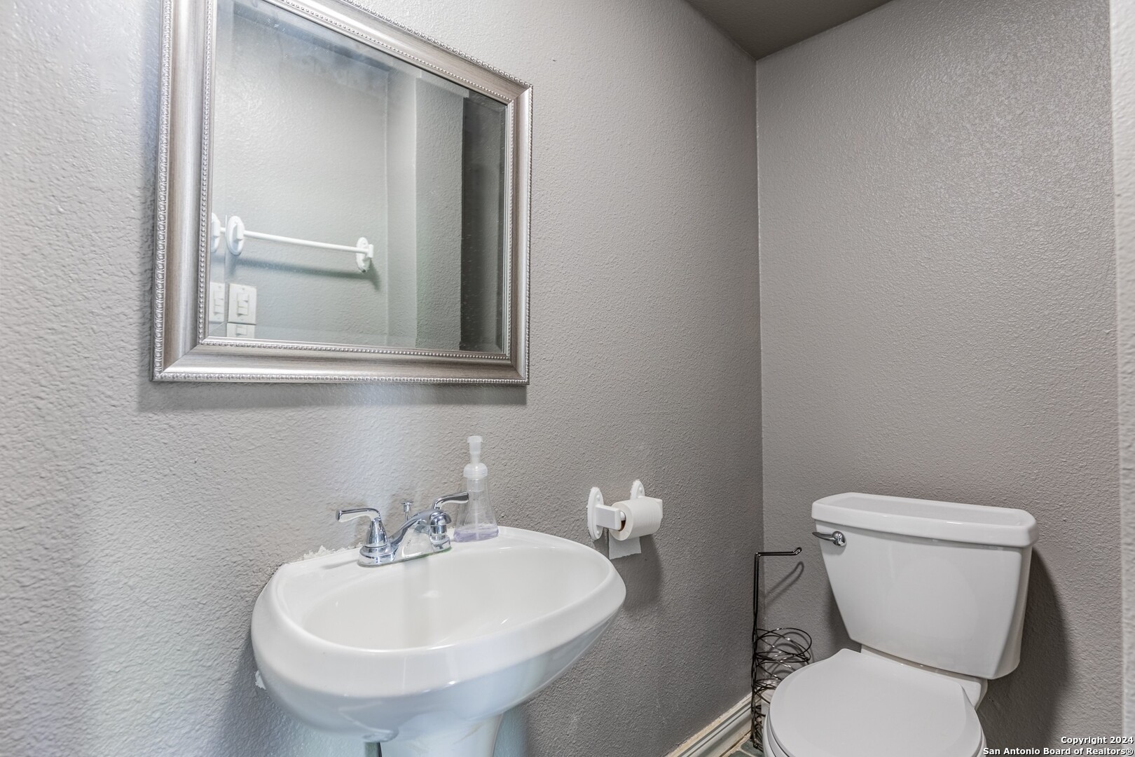 7802 Rimfire Drive San Antonio, TX 78227 - Photo 23 of 39 a bathroom with a toilet a sink and mirror