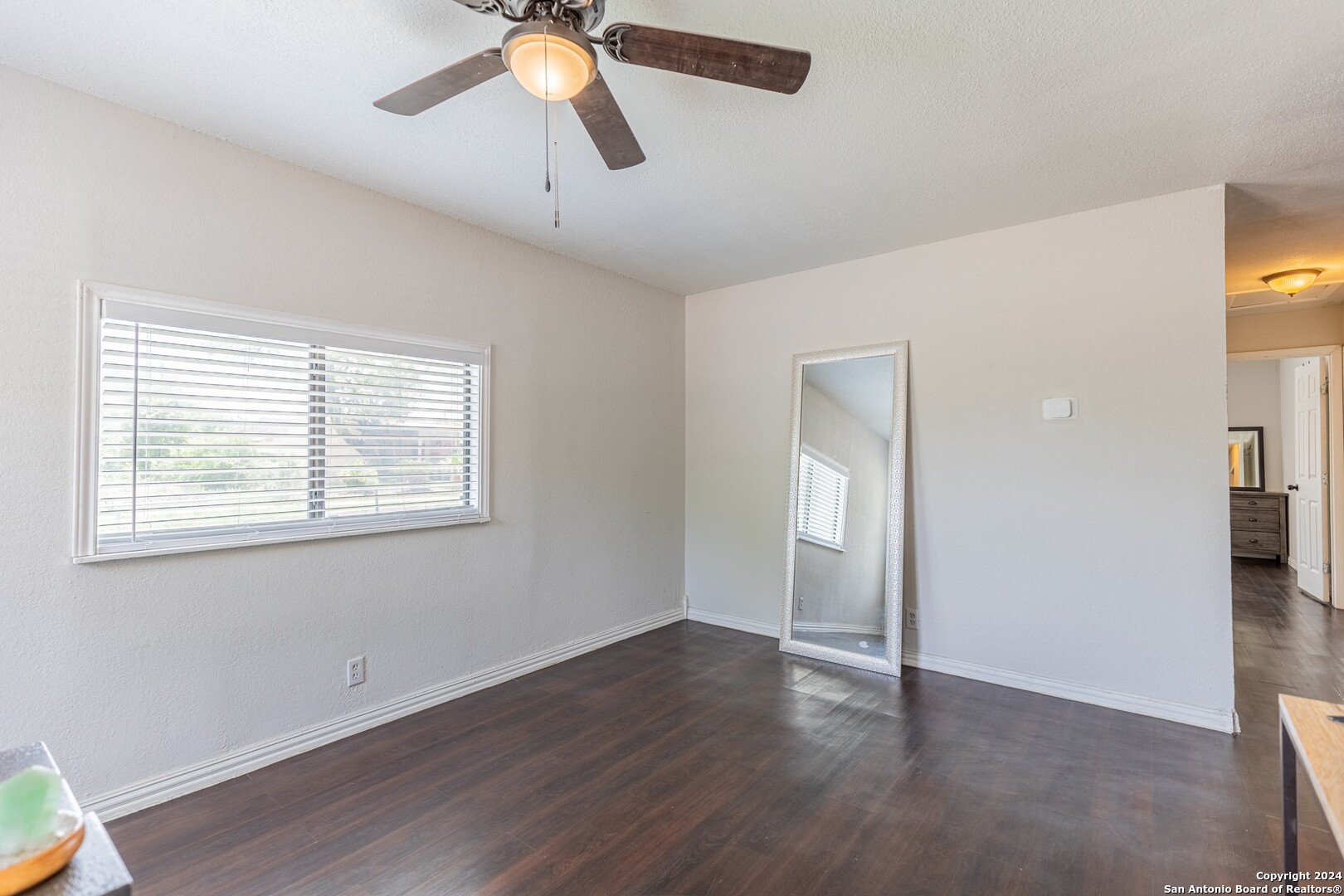 7802 Rimfire Drive San Antonio, TX 78227 - Photo 4 of 39 a view of an empty room with window and wooden floor