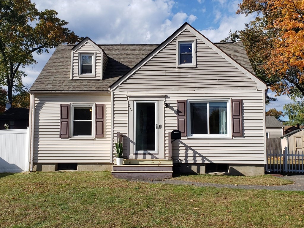 a view of a house with backyard and a tree