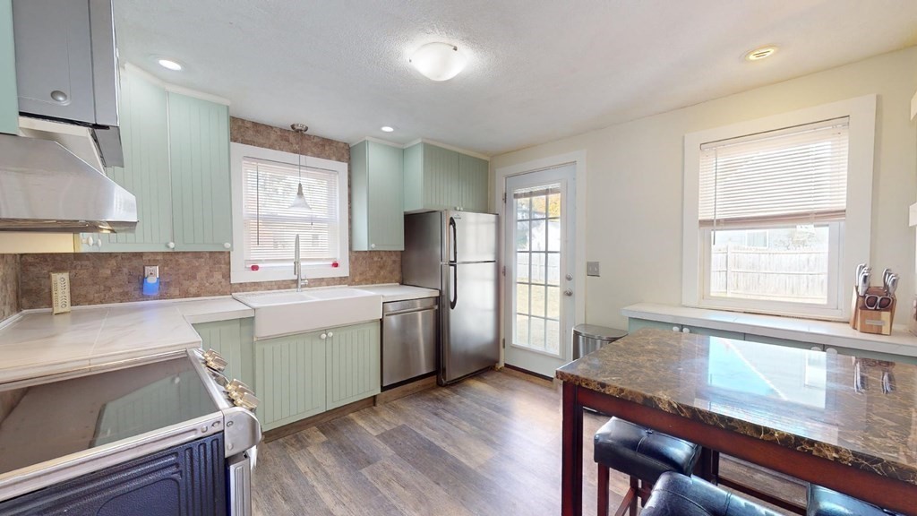 274 Cooper Street Springfield, MA 01108 - Photo 6 of 42 a kitchen with a table chairs sink and refrigerator