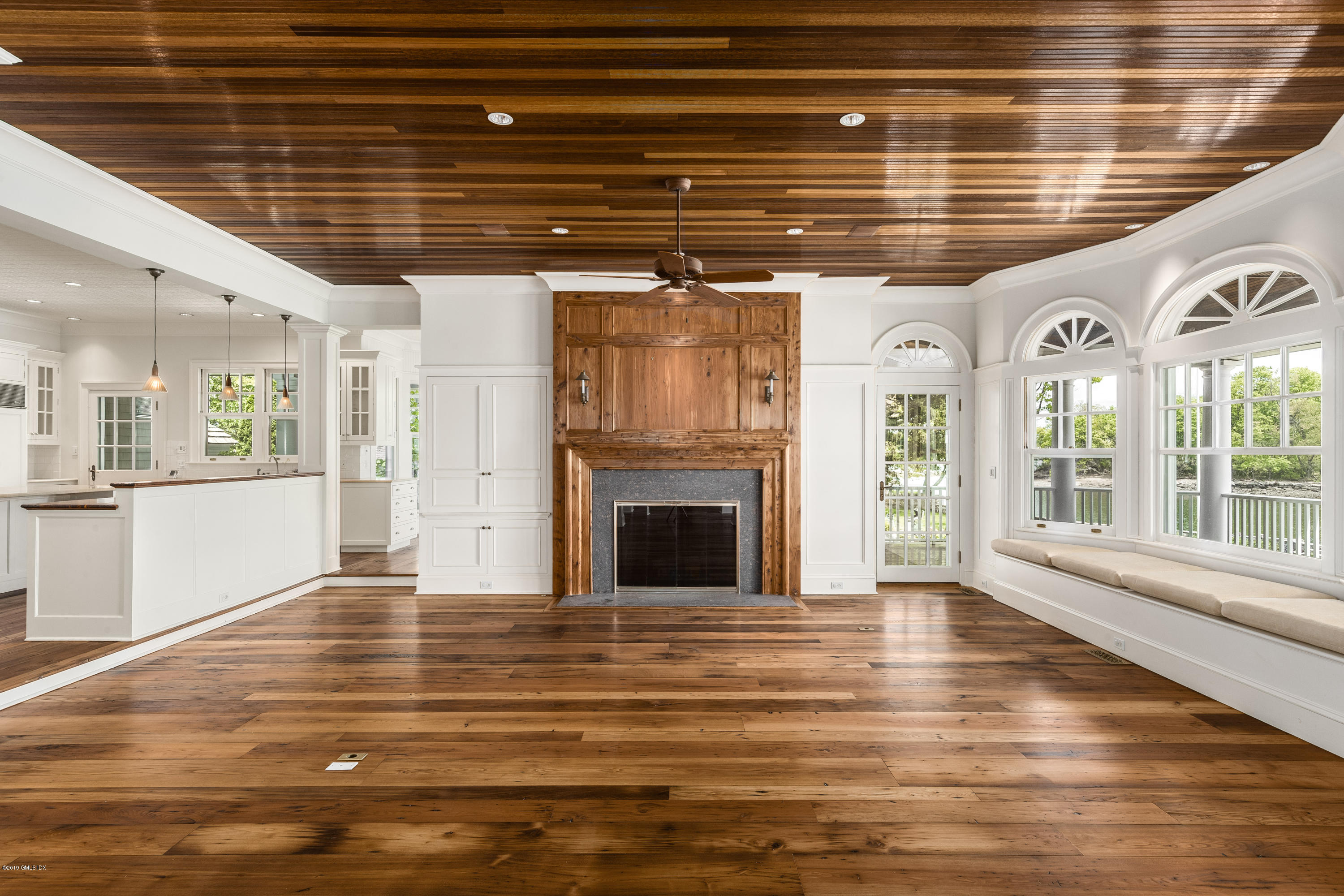 35 Byram Shore Road Greenwich, CT 06830 - Photo 10 of 32 a view of an empty room with wooden floor and a kitchen