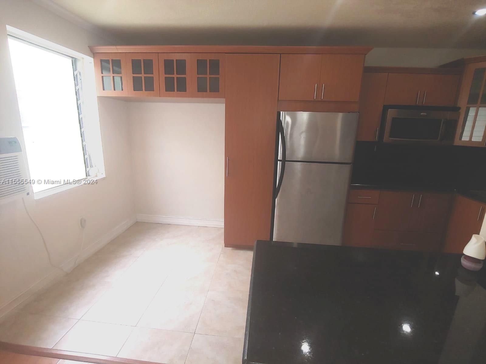 7928 Harding Avenue, Unit 8 Miami Beach, FL 33141 - Photo 11 of 30 a view of a refrigerator in kitchen and wooden floor