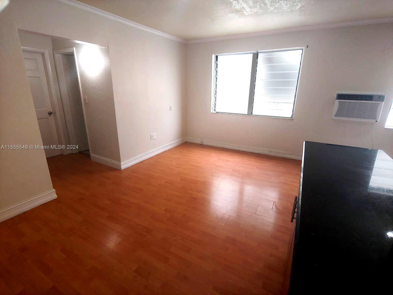 7928 Harding Avenue, Unit 8 Miami Beach, FL 33141 - Photo 12 of 30 an empty room with wooden floor and windows