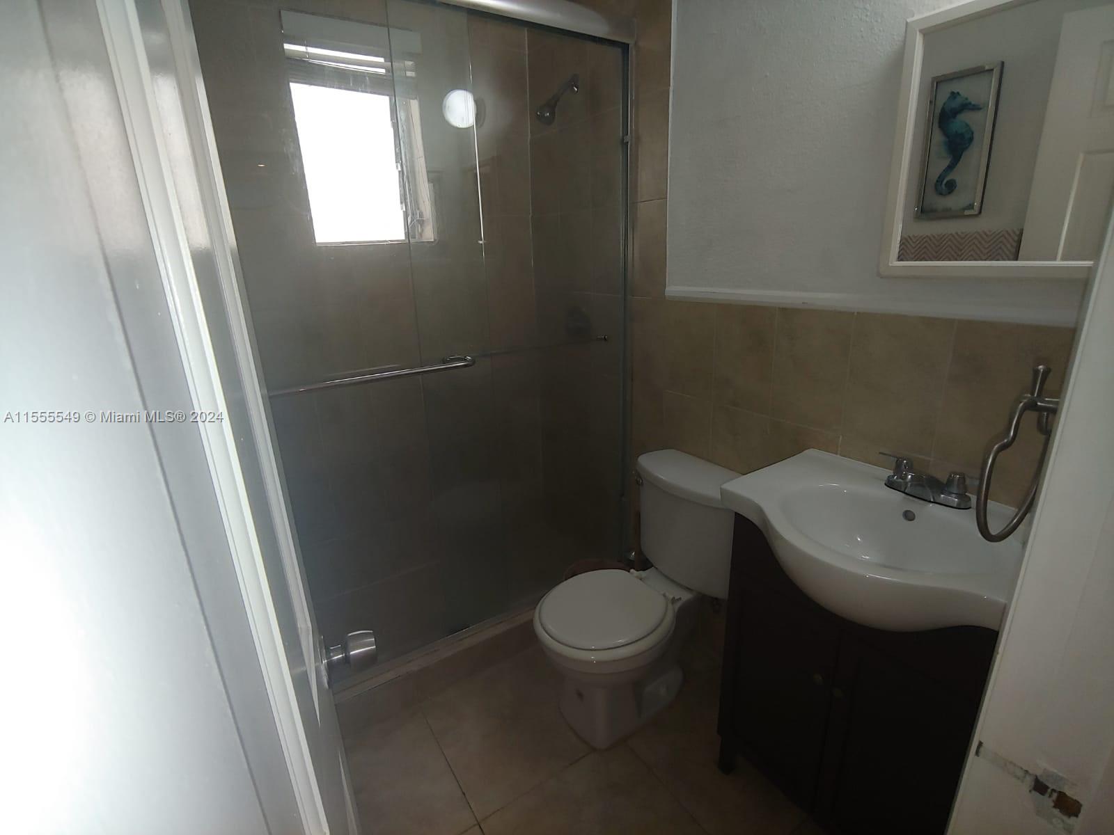 7928 Harding Avenue, Unit 8 Miami Beach, FL 33141 - Photo 28 of 30 a bathroom with a toilet sink and mirror