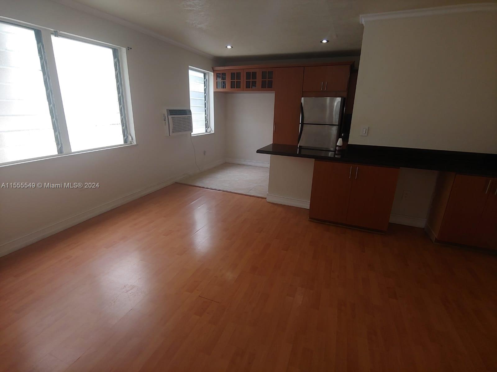 7928 Harding Avenue, Unit 8 Miami Beach, FL 33141 - Photo 30 of 30 an empty room with wooden floor and windows