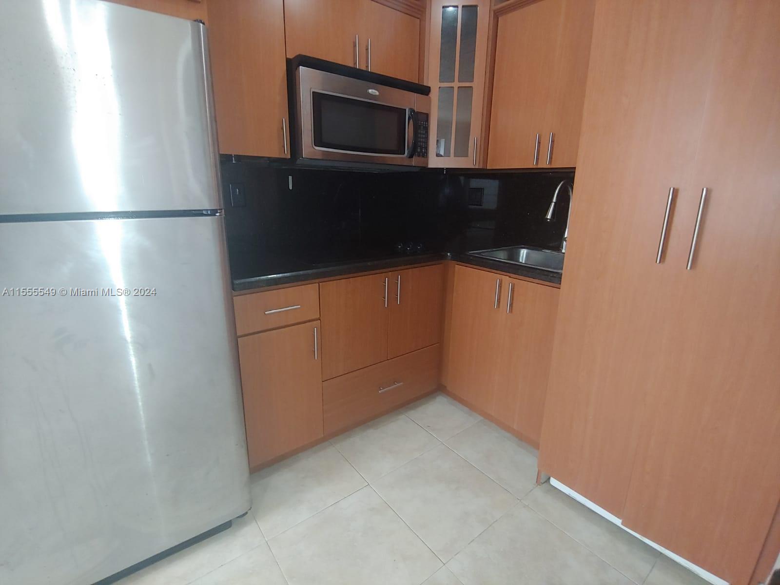 7928 Harding Avenue, Unit 8 Miami Beach, FL 33141 - Photo 5 of 30 a kitchen with a refrigerator and microwave