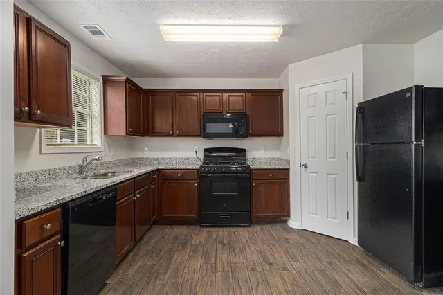 a kitchen with granite countertop stainless steel appliances and wooden cabinets