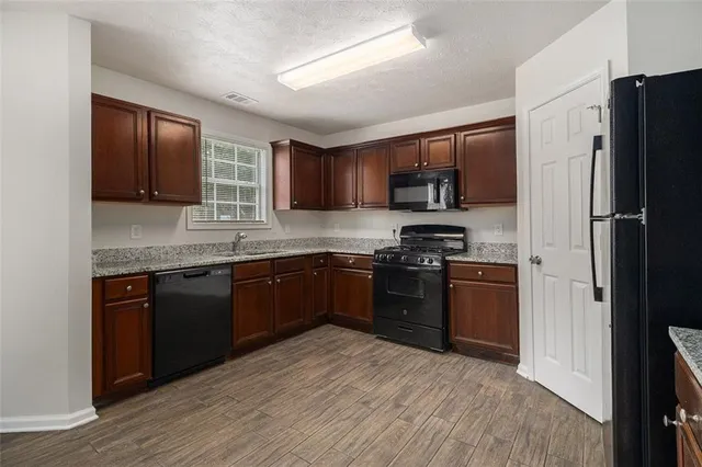a kitchen with granite countertop stainless steel appliances and wooden cabinets