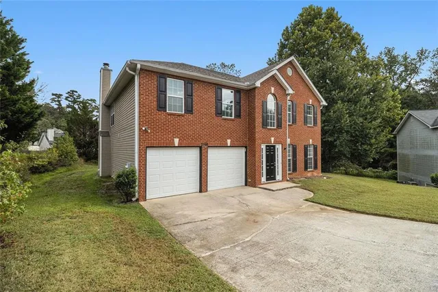 a front view of a house with a yard and garage