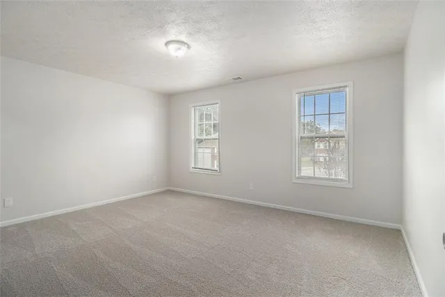 a bathroom with a granite countertop toilet sink and mirror