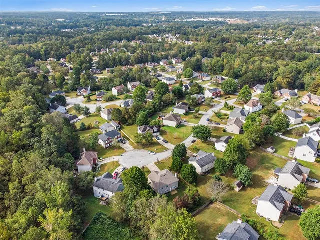 an aerial view of residential houses with outdoor space and trees
