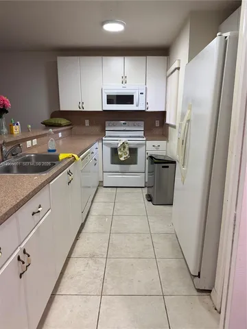 a kitchen with stainless steel appliances granite countertop a refrigerator sink and stove