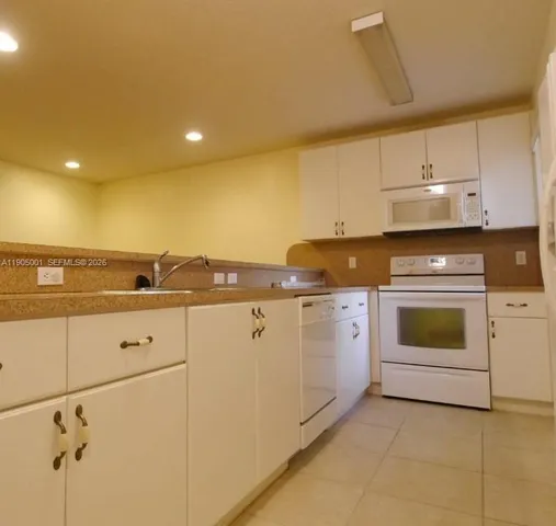 a kitchen with cabinets and white appliances